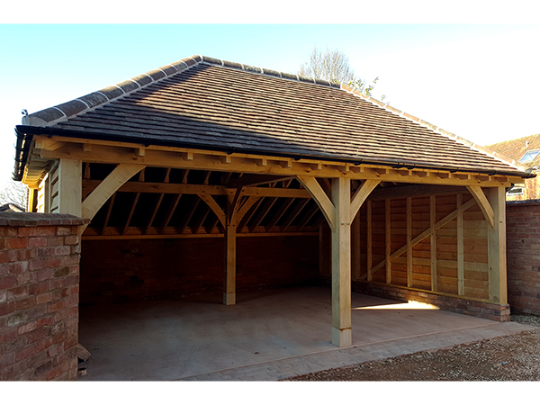 Oak framed 2 bay garage with hipped roof by Shires Oak Buildings