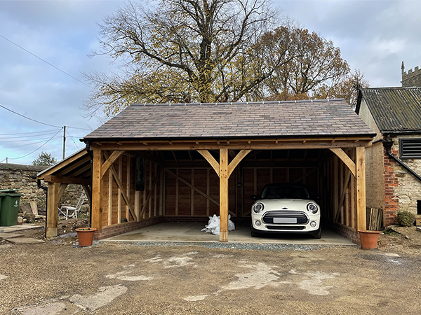 Oak framed 2 bay garage with logstore by Shires Oak Buildings
