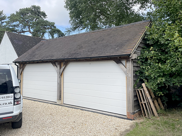 Oak framed 2 bay catslide garage with automated doors by Shires Oak Buildings